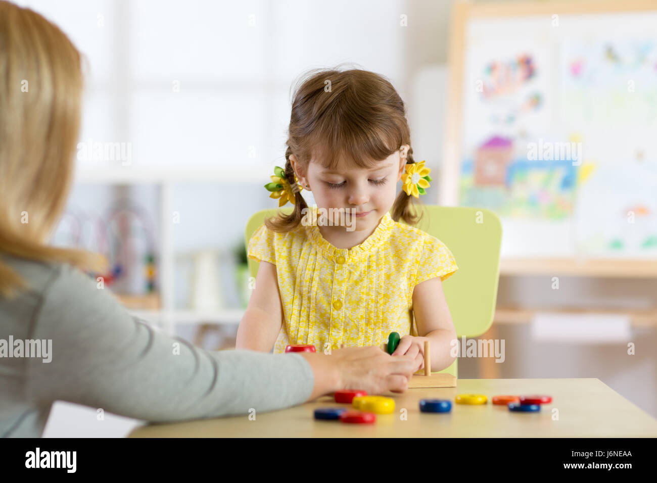 Tutor e preschooler kid giocare con dei giocattoli educativi Foto Stock