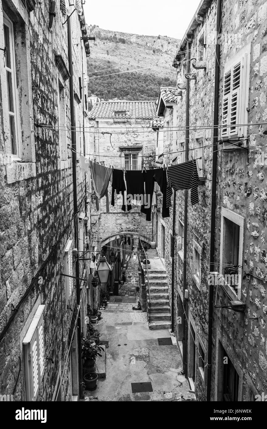 Guardando verso il basso su una stretta ma piuttosto Street nel cuore dell'area della città vecchia di Dubrovnik in Croazia del Sud. La maggior parte dei locali spostato fuori della città alcuni ti Foto Stock