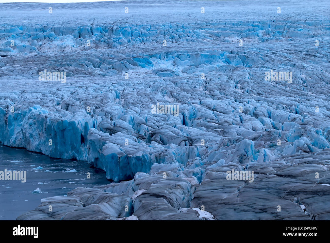 Dure ghiacciai dell'Artico. Il ghiacciaio dal vivo. Cascata di ghiaccio su high rock bar. Novaya Zemlya arcipelago, isola del Nord. Vista dall'elicottero Foto Stock