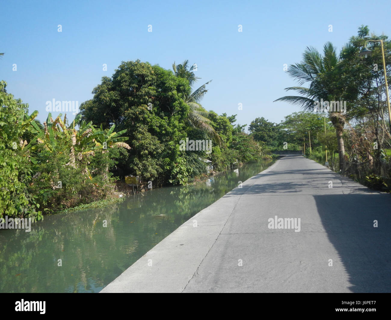 Banga Santa Ines Agnaya Road a Plaridel, Bulacan, è una strada rurale chiave che collega i sistemi di irrigazione e i mercati agricoli, sostenendo le attività agricole e il commercio locale. Foto Stock Banga Santa Ines Agnaya Road a Plaridel, Bulacan, è una strada rurale chiave che collega i sistemi di irrigazione e i mercati agricoli, sostenendo le attività agricole e il commercio locale. Foto Stock