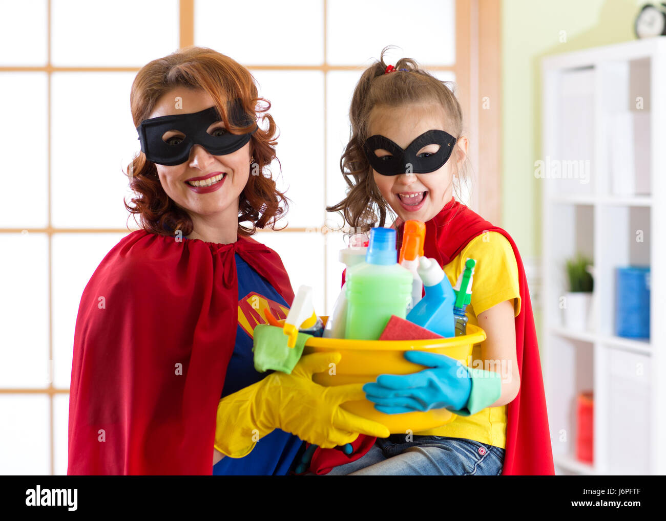 La madre e il figlio di lei in costume da supereroe. Mamma e Bambino pronto per la pulizia della casa. Houseworking e il servizio di pulizie. Foto Stock