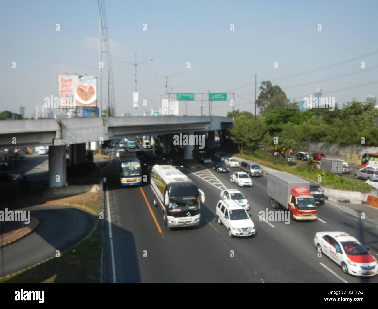 Una fotografia che cattura l'area di Forbes Park a Makati, parte del quartiere centrale della metropolitana di Manilaâ. L'immagine include viste delle strade locali, della stazione MRT di Buendia e di EDSA Road, che mostrano lo sviluppo urbano della zona. Foto Stock