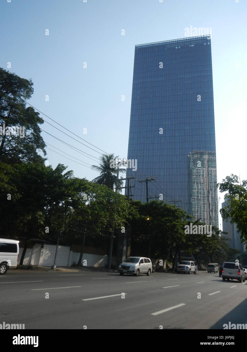 Una vista dell'edificio Urdaneta Zuellig situato in One Roxas Triangle sul Paseo de Roxas e Gil Puyat a Makati, Filippine. La fotografia mette in evidenza l'architettura dell'edificio e la sua posizione in uno dei principali quartieri commerciali della città. Foto Stock
