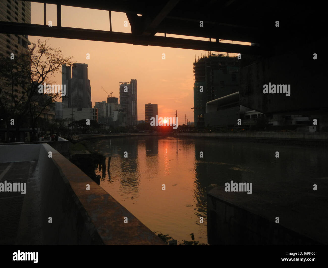 Questo titolo si riferisce a una scena o a una fotografia che mostra il tramonto sulle proprietà Century City e Makati Mall a Makati City, evidenziando lo skyline urbano al crepuscolo nelle Filippine. Foto Stock