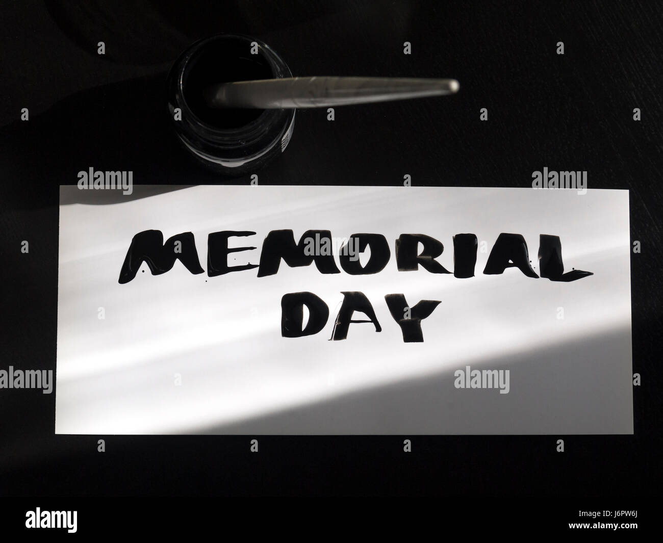 Il memorial day la calligrafia e il lettering post card con inkstand. Vista dall'alto di luce e di ombra. Foto Stock