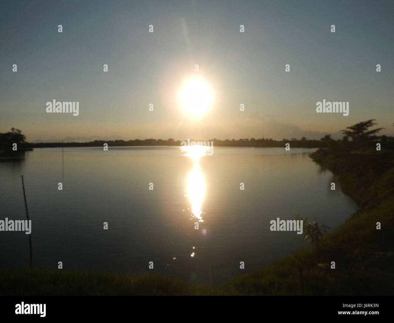 Questo si riferisce a una strada o un luogo a Minalin, Pampanga, Filippine, incentrato su San Nicolas Poblacion e Acacia Boulevard. L'area è caratterizzata da edifici residenziali e commerciali che contribuiscono al paesaggio urbano della regione. Foto Stock