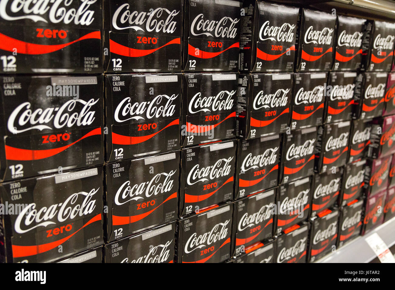 Casi di Coca Cola soda in esposizione su scaffali di un negozio di alimentari Foto Stock
