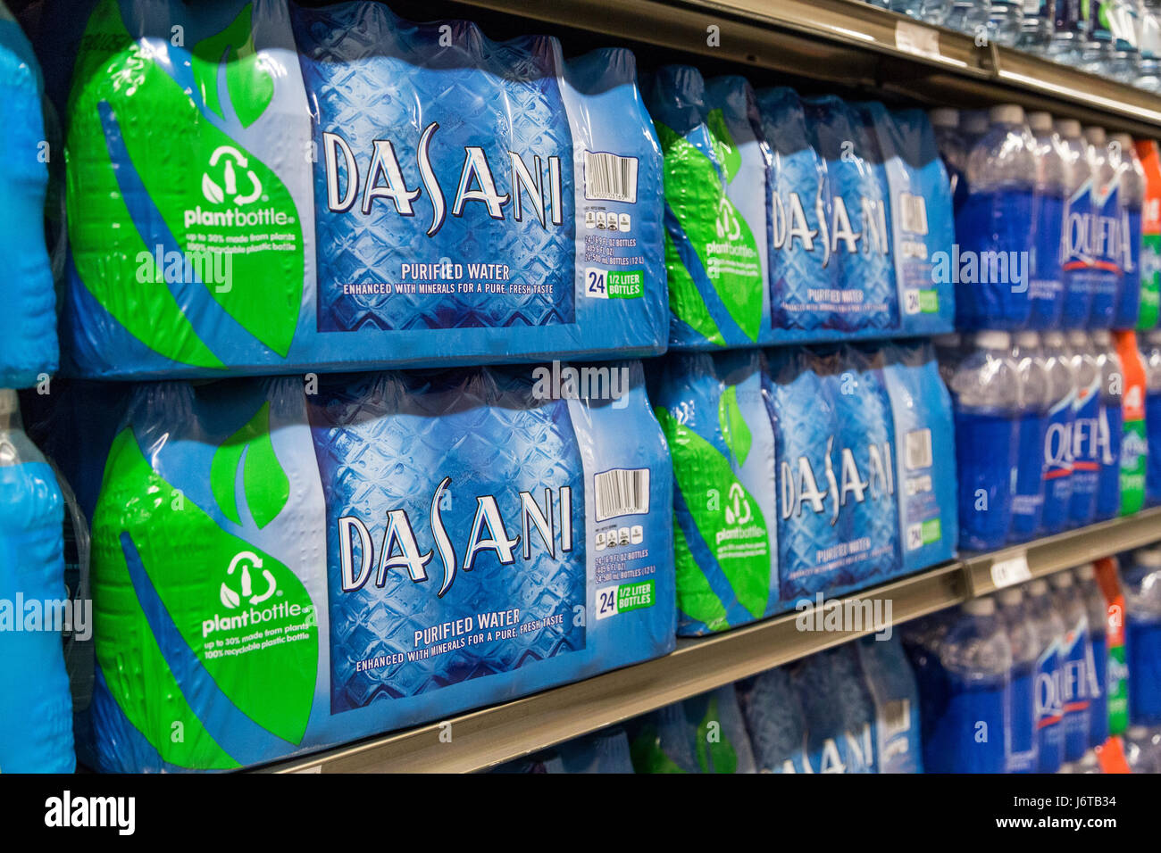 Pacchetti di marchio Dasani bottiglie acqua sedersi sugli scaffali di un negozio di alimentari Foto Stock