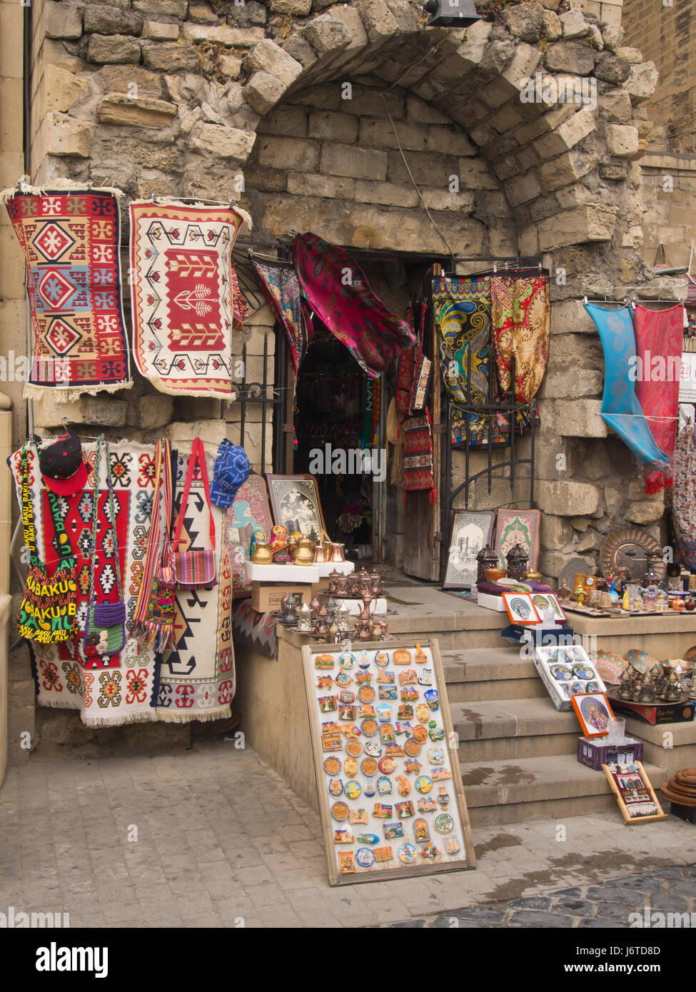 Negozio di souvenir in vendita nella città vecchia cinta di mura di Baku  Azerbaigian, tappeti, magneti per il frigo, sciarpe, borse e altro ancora  in un display a colori Foto stock -