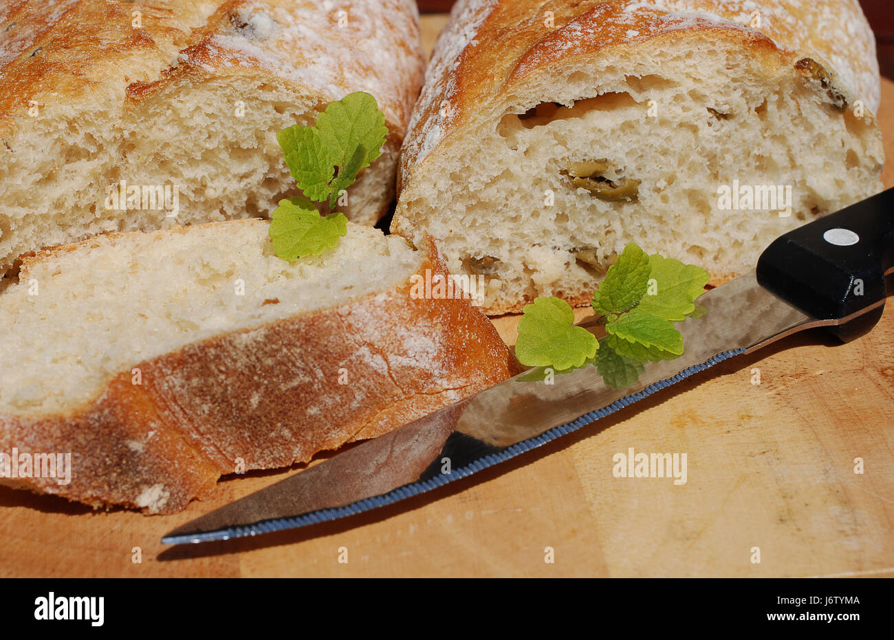 Pane francese pane baguette disco scheda di legno baguette francese cotta braccio slice Foto Stock