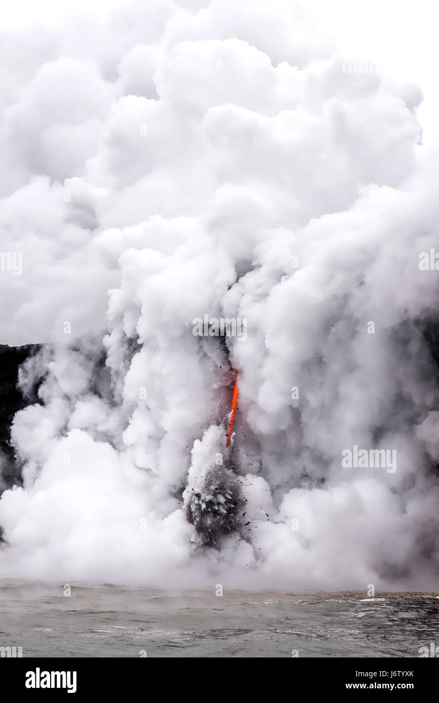 Un flusso di lava sulla Big Island delle Hawaii conosciute come la manichetta antincendio ne immette nell'atmosfera magma fuso dal vulcano Kilauea nell'oceano, causando esplosioni e forma Foto Stock