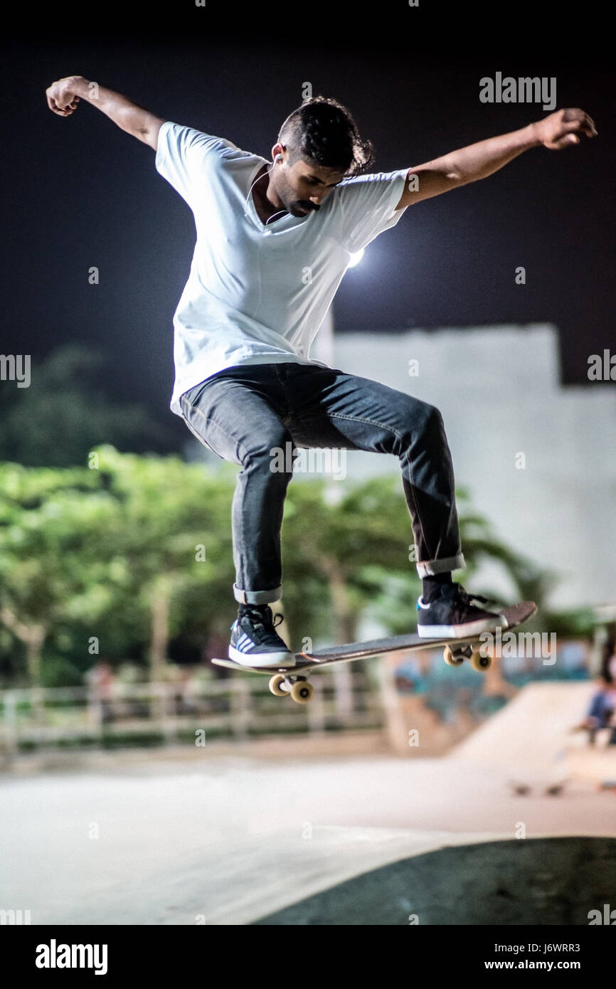 Guidatore di skateboard in uno skatepark in Bangalore, India, di preformare un trucco di sera. Foto Stock Guidatore di skateboard in uno skatepark in Bangalore, India, di preformare un trucco di sera. Foto Stock