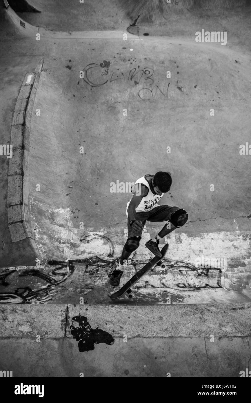 Immagine di un guidatore di skateboard preformare un trucco in uno skatepark a Bangalore in India. Foto Stock
