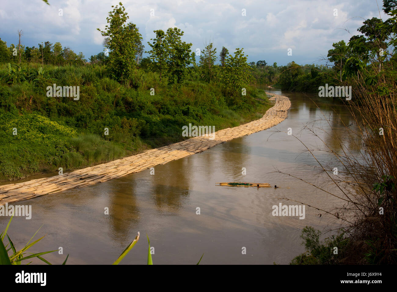 Bambù sono legate insieme come le zattere sono flottanti in allontanamento al mercato con la corrente del fiume Machalang. Rangamati, Bangladesh. Foto Stock