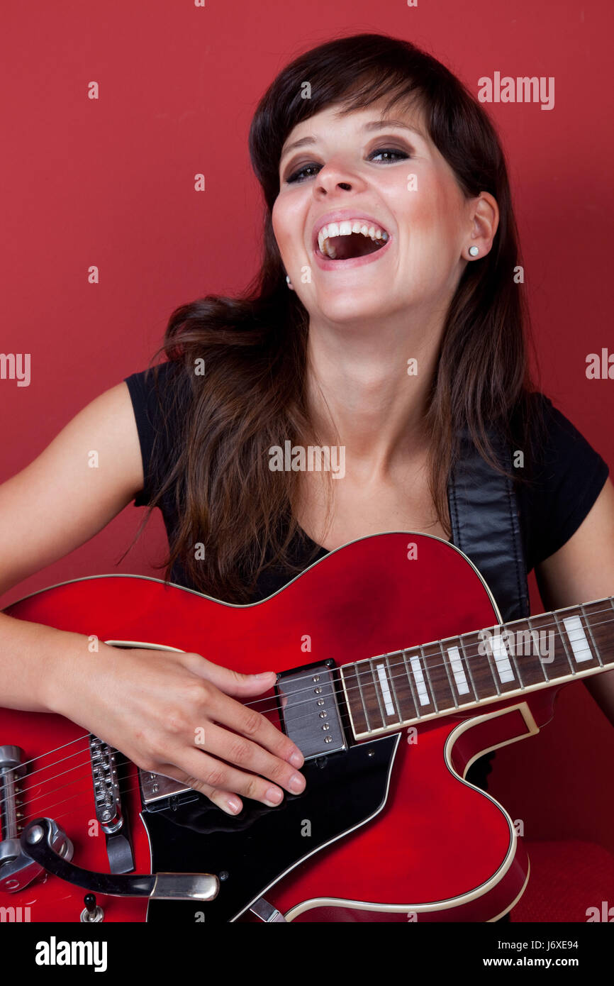 All'interno di frau gitarre rot wand singen musik spa lachen frau gitarre bacchetta di ROT Foto Stock