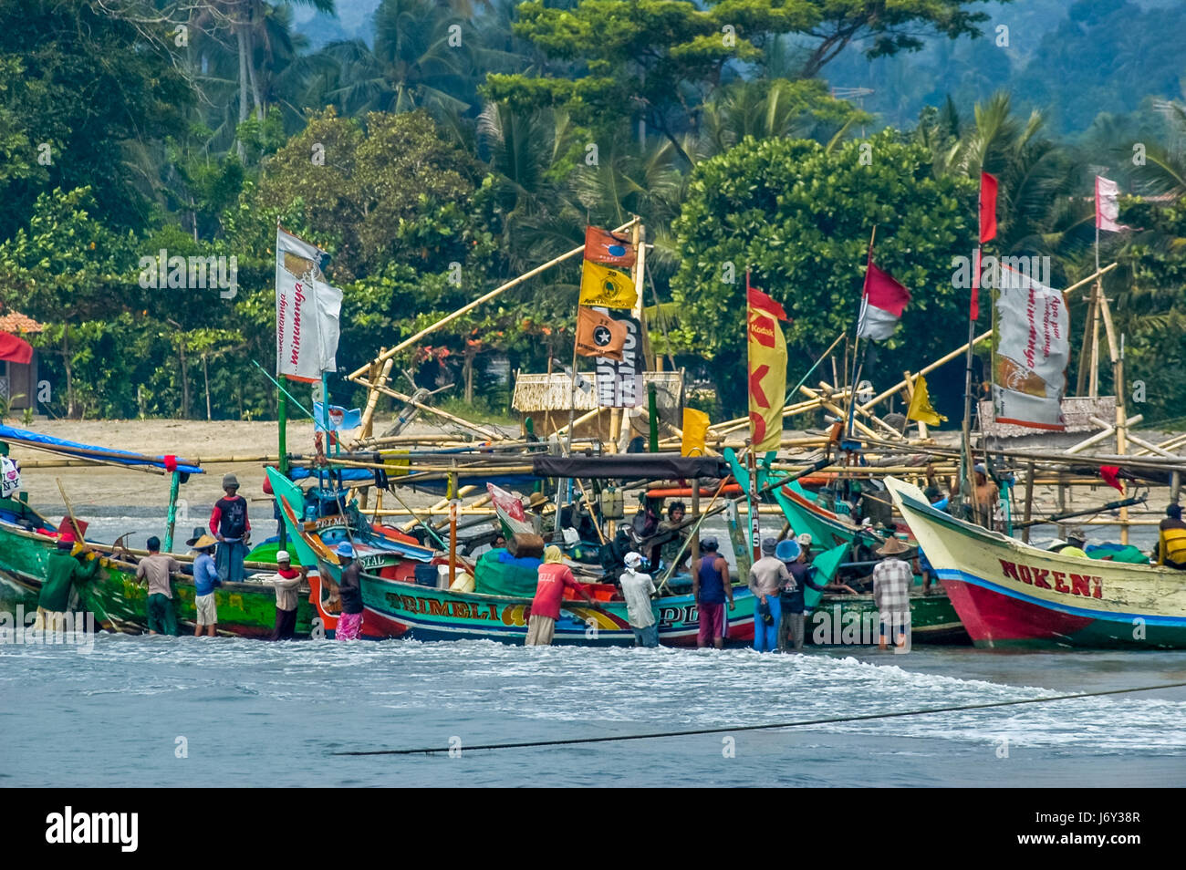 Pescatori che preparano barche da pesca sulla spiaggia di Carita a Pandeglang, Banten, Indonesia. Foto Stock