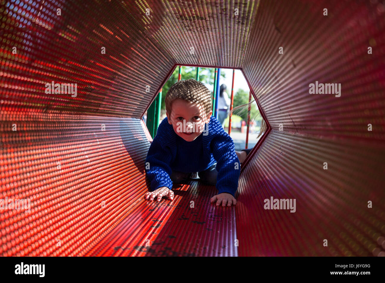 Bambini che giocano in rosso delle attrezzature da gioco,nonage,sport stolto romp cani romped felicemente in giardino. revel inezia cappero i bambini erano capering circa, Foto Stock