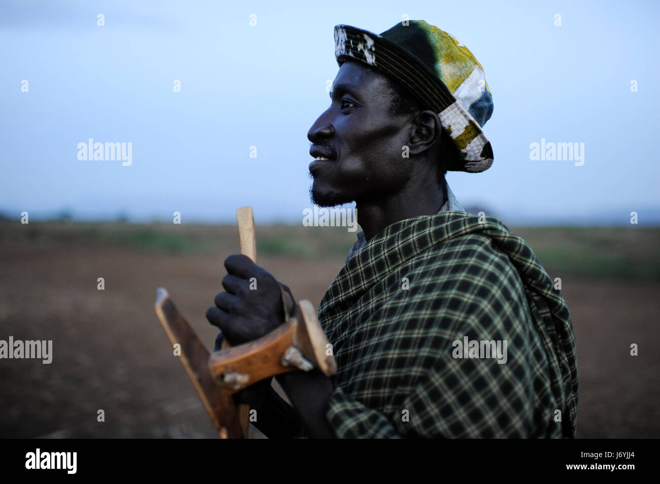 KENYA Regione Turkana, Kakuma , qui i Turkana una tribù nilotica vivono, Turkana l uomo con il suo sgabello in legno / Kenia Turkana Regione , Kakuma, hier leben die Turkana ein nilotisches Volk, Turkana Mann mit Holzhocker Foto Stock