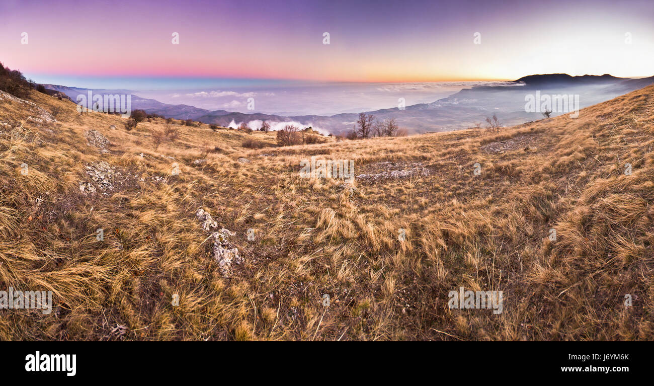 Purpureo tramonto in montagna sopra il mare Foto Stock