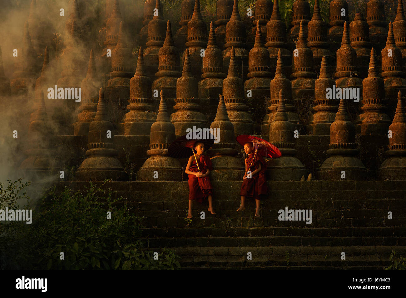 Due monaci novizio seduto sul tempio, Mrauk-U Ratanabon Paya, Myanmar Foto Stock