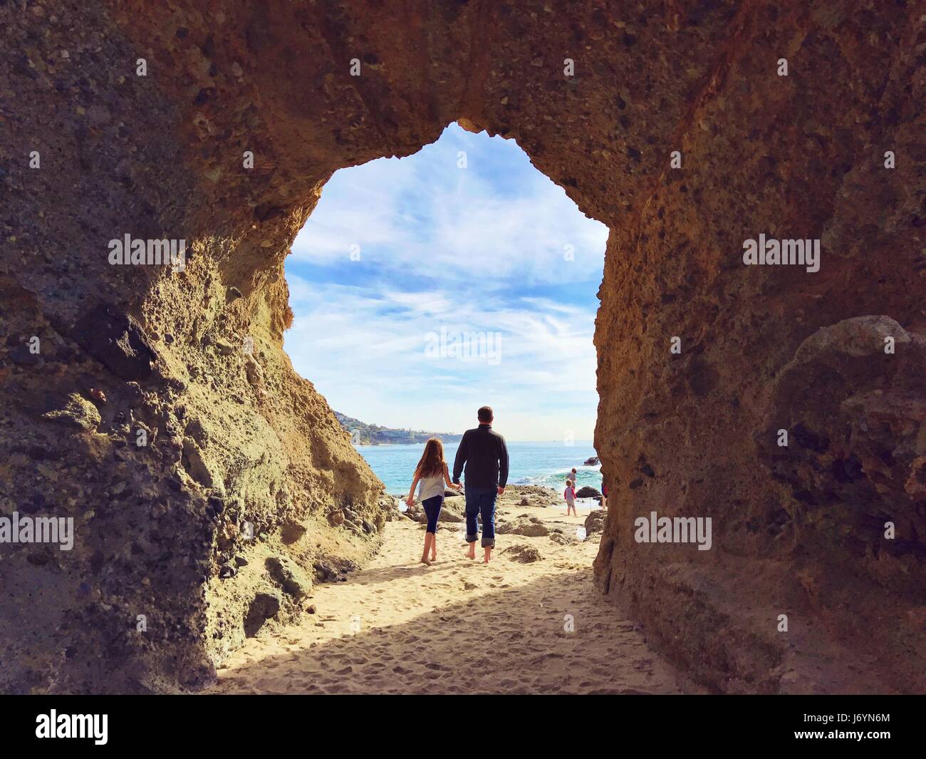 padre e figlia sulla spiaggia camminando verso il resto della loro famiglia, San Diego, California, Stati Uniti Foto Stock