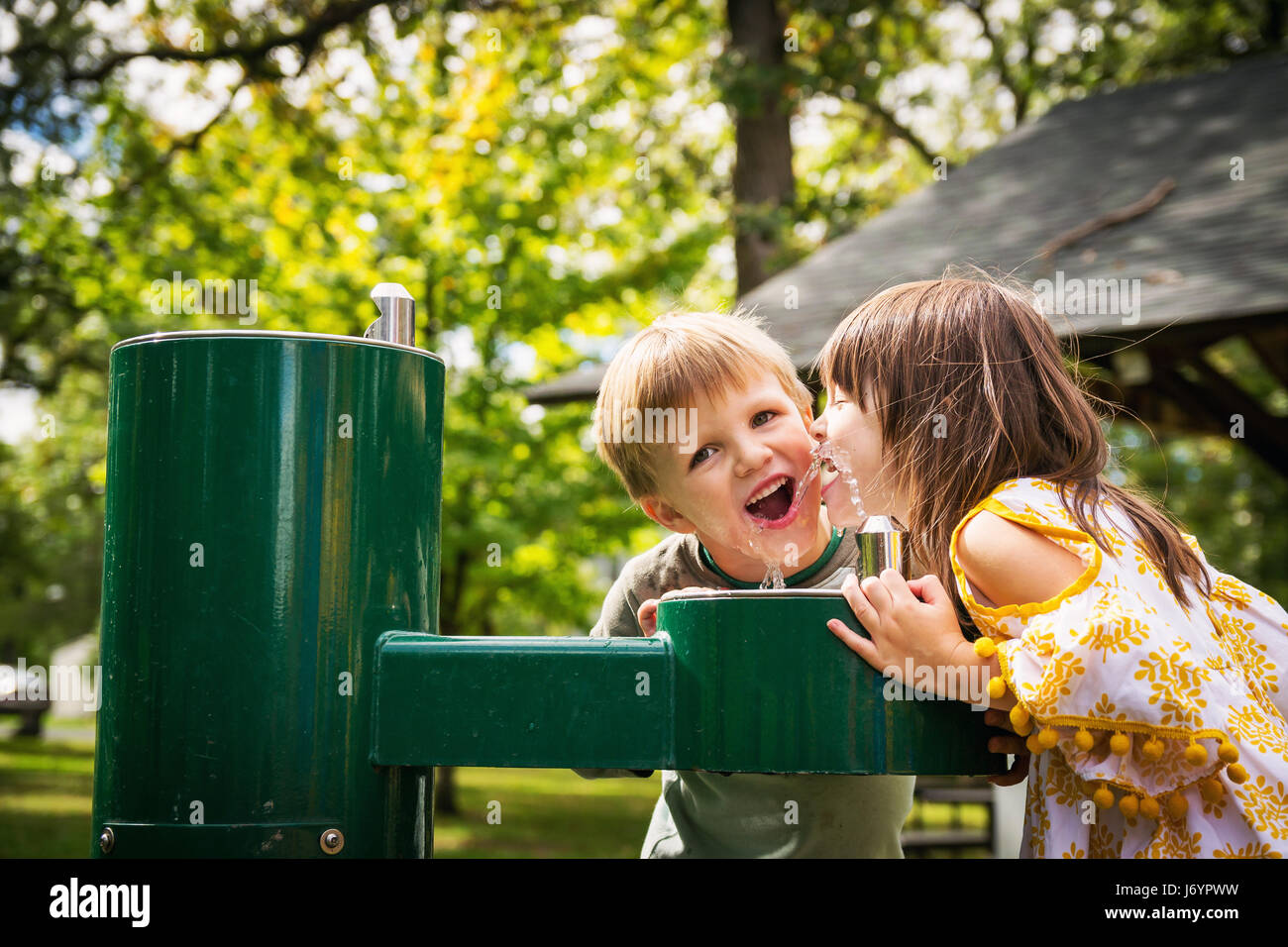 Due bambini di bere da una fontana di acqua Foto Stock