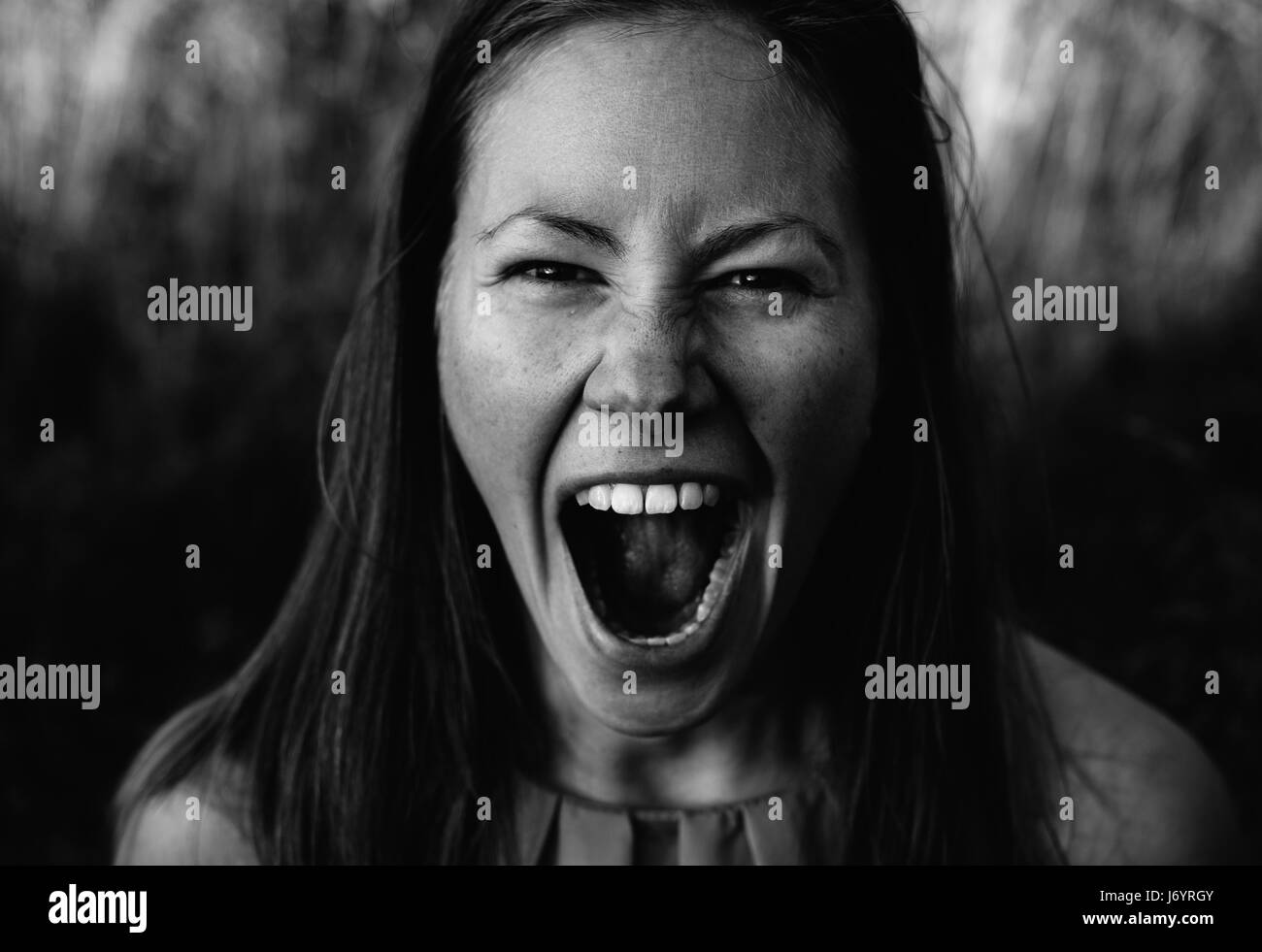 Bianco e nero ritratto di giovane donna attraente urlando Foto Stock