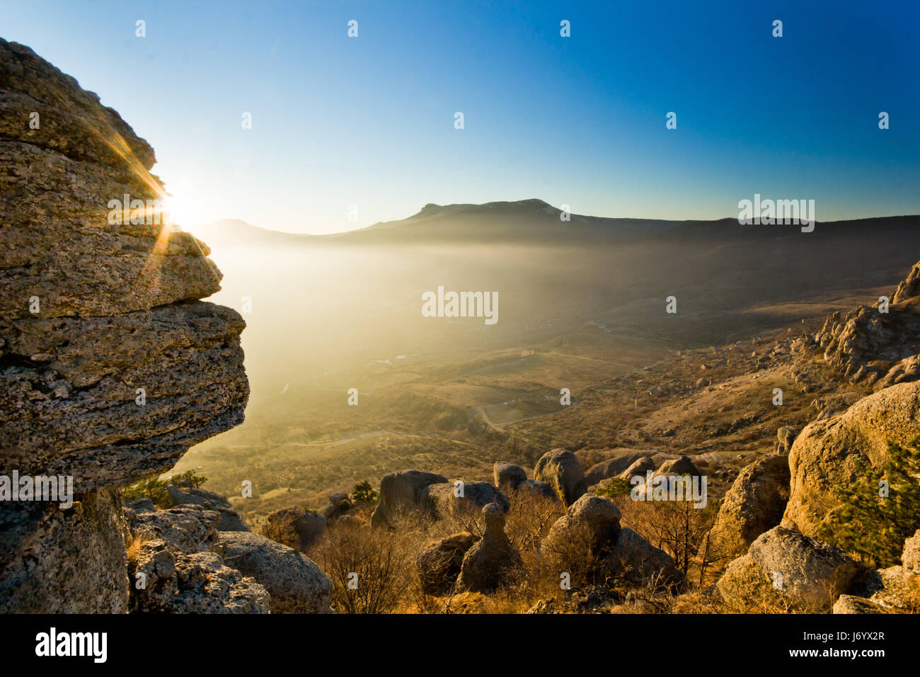 Sole splende sopra la pietra in montagna al tramonto Foto Stock
