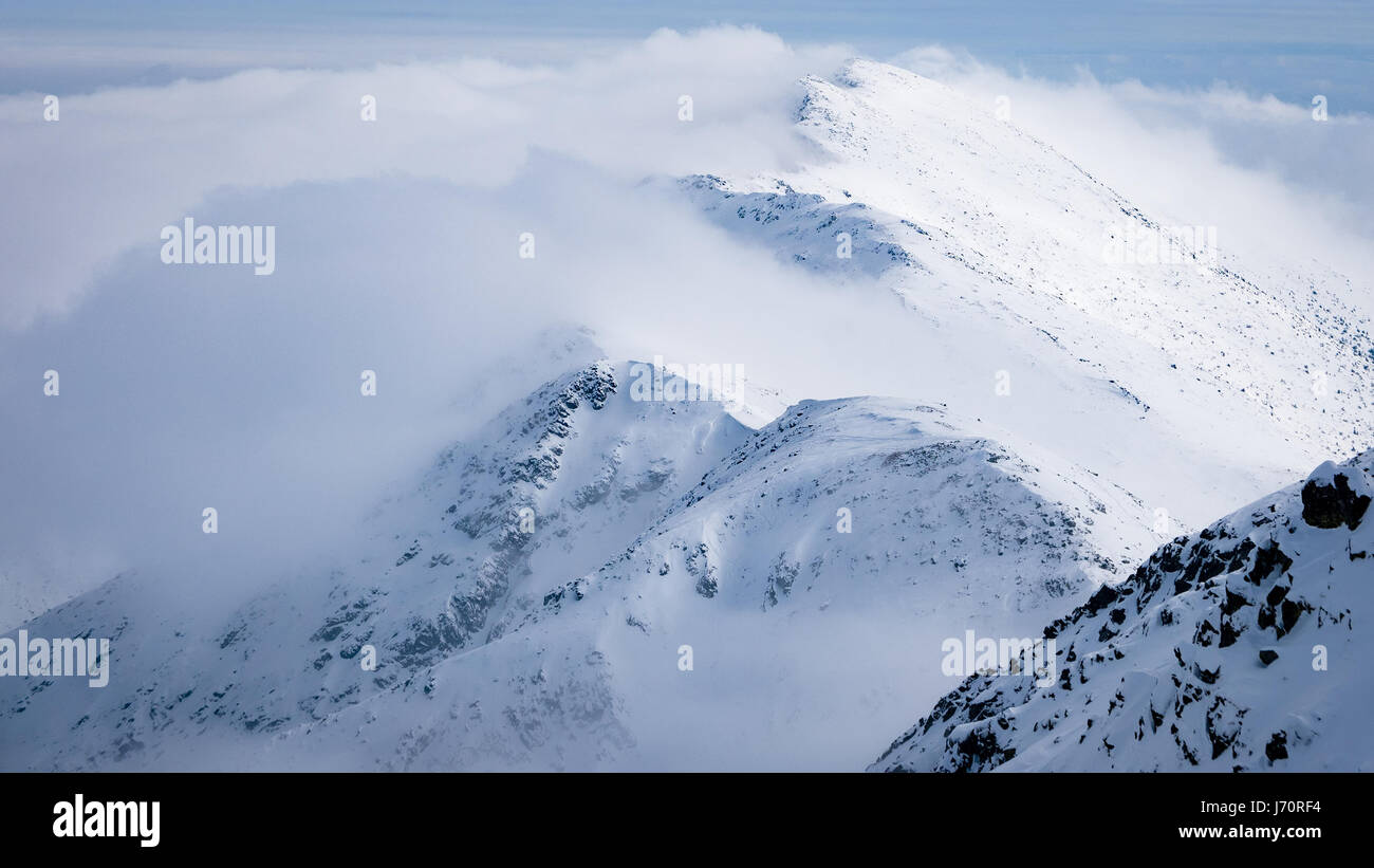 Punti più alti dei Bassi Tatra - Chopok peak e peak Dumbier (Slovacchia). Belle montagne invernali il paesaggio al di sopra delle nuvole. Foto Stock