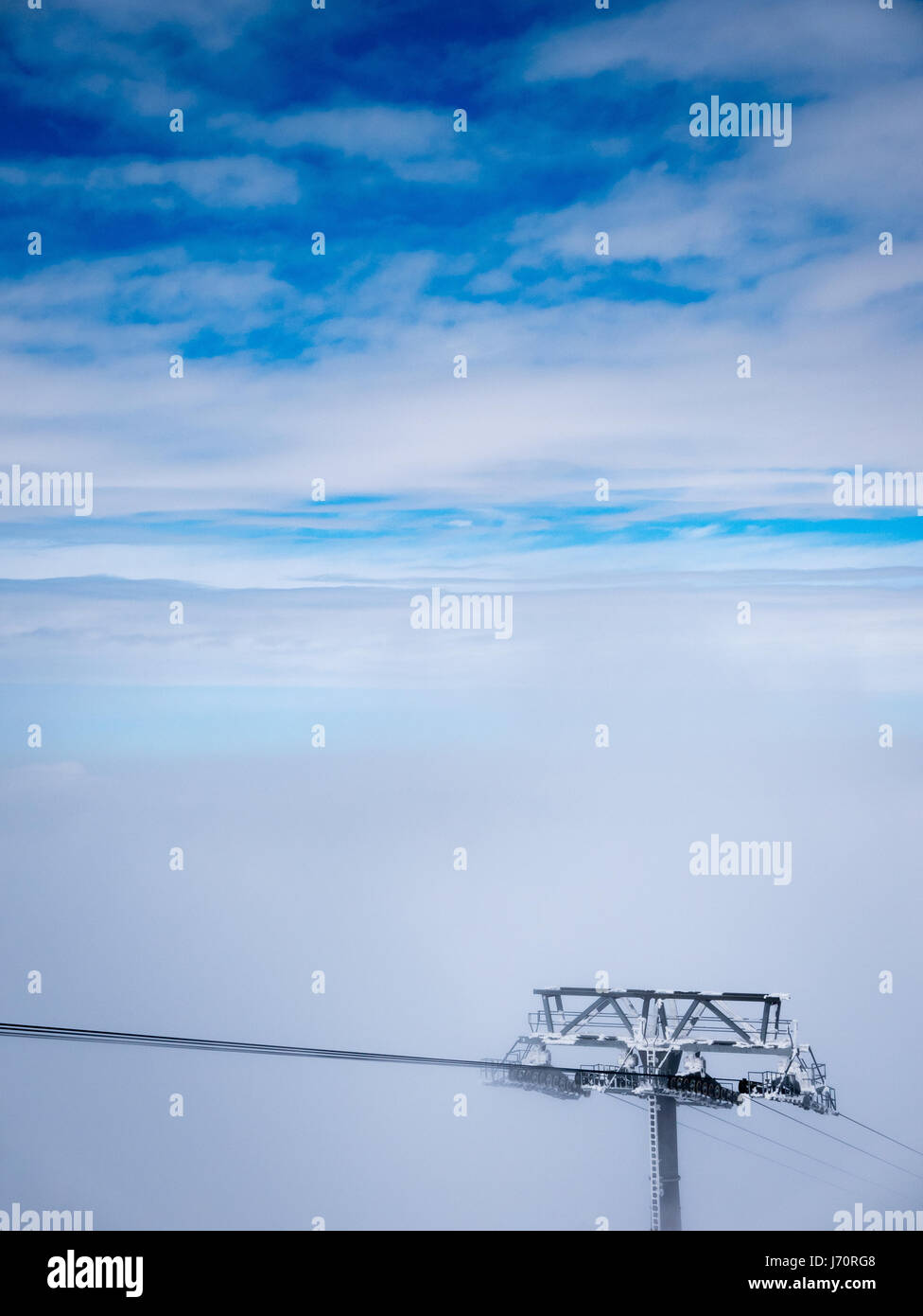 Parte superiore della funivia di sci polo sulle nuvole e cielo blu. Foto Stock