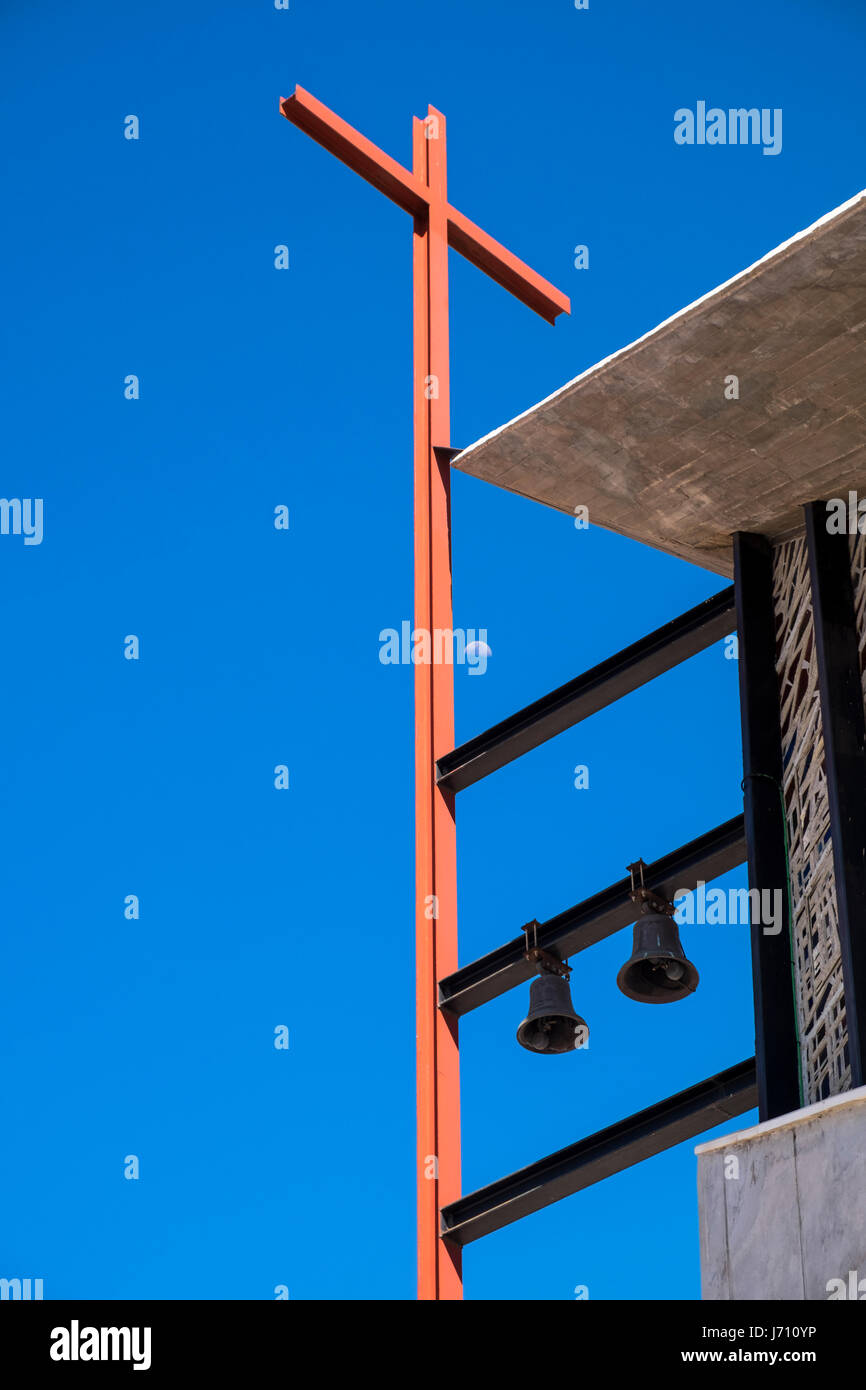 Rosso in acciaio rsj crocifisso, croce e campane sulla facciata del Callao Salvaje comunità chiesa in Adeje, Tenerife, Isole Canarie, Spagna Foto Stock