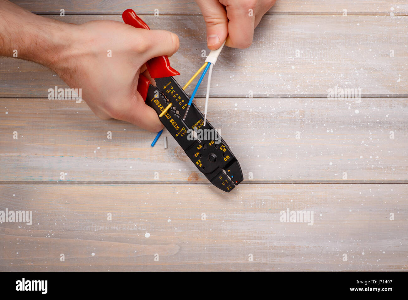 Il processo di estrazione del filo con un attrezzo speciale - isolamento stripper Foto Stock