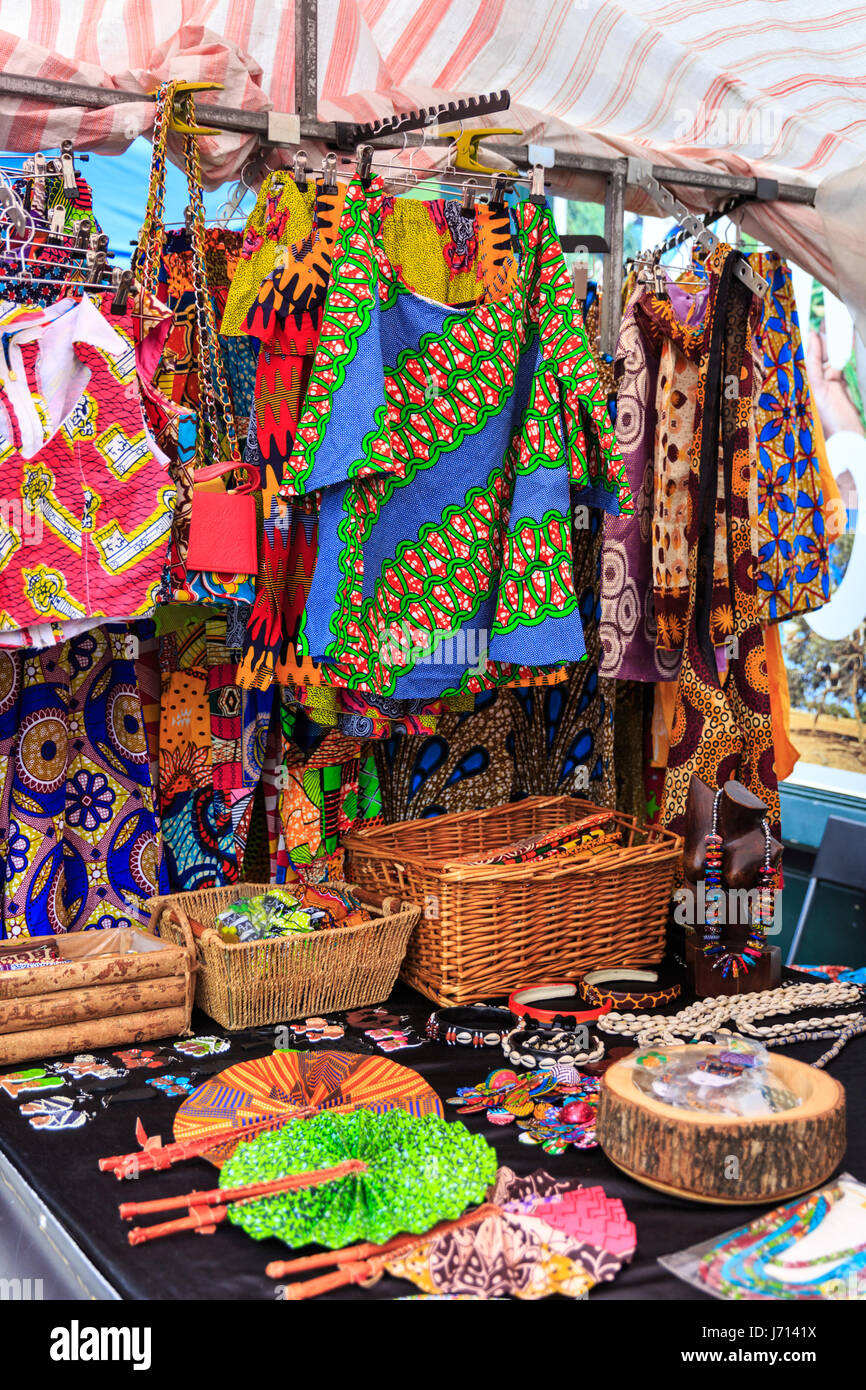 Tessuti africani colorati, abiti, modelli e regali in una bancarella in Brixton Market, Brixton, Londra, Regno Unito Foto Stock