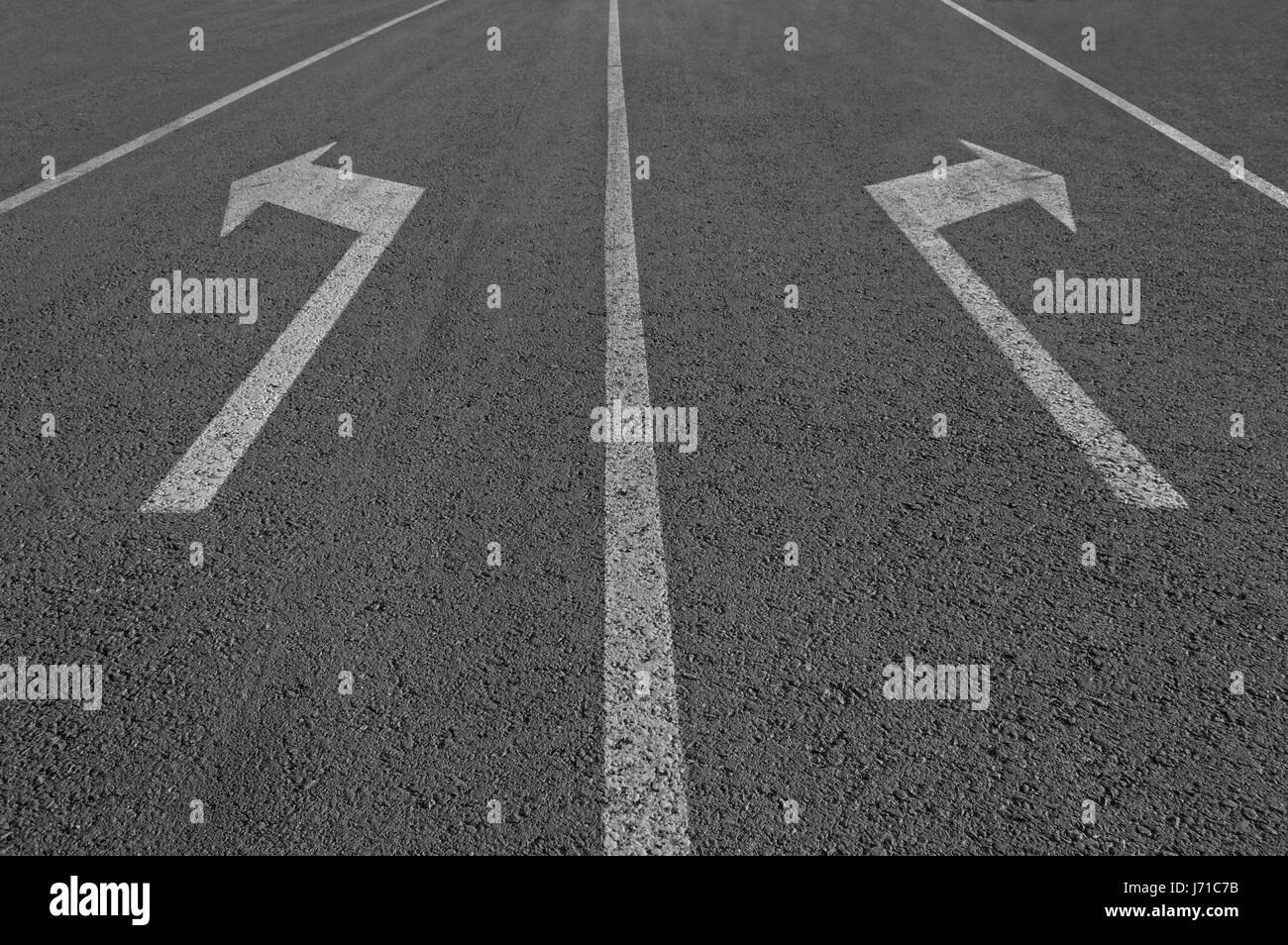 Due modo segno frecce su strada asfaltata. Foto Stock