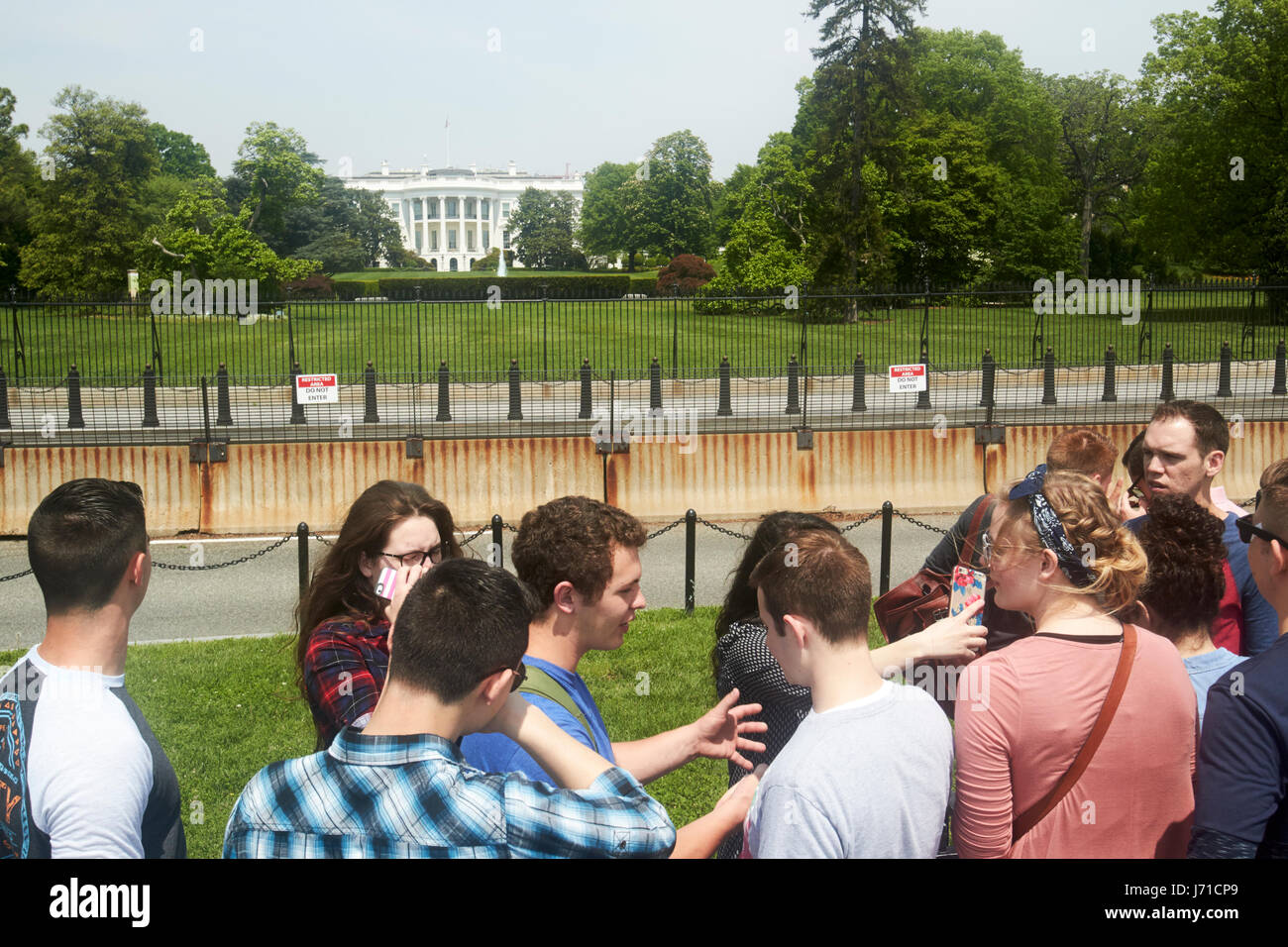 I turisti prendono selfies al di fuori delle barriere di sicurezza sulla south lawn della casa bianca a Washington DC USA Foto Stock
