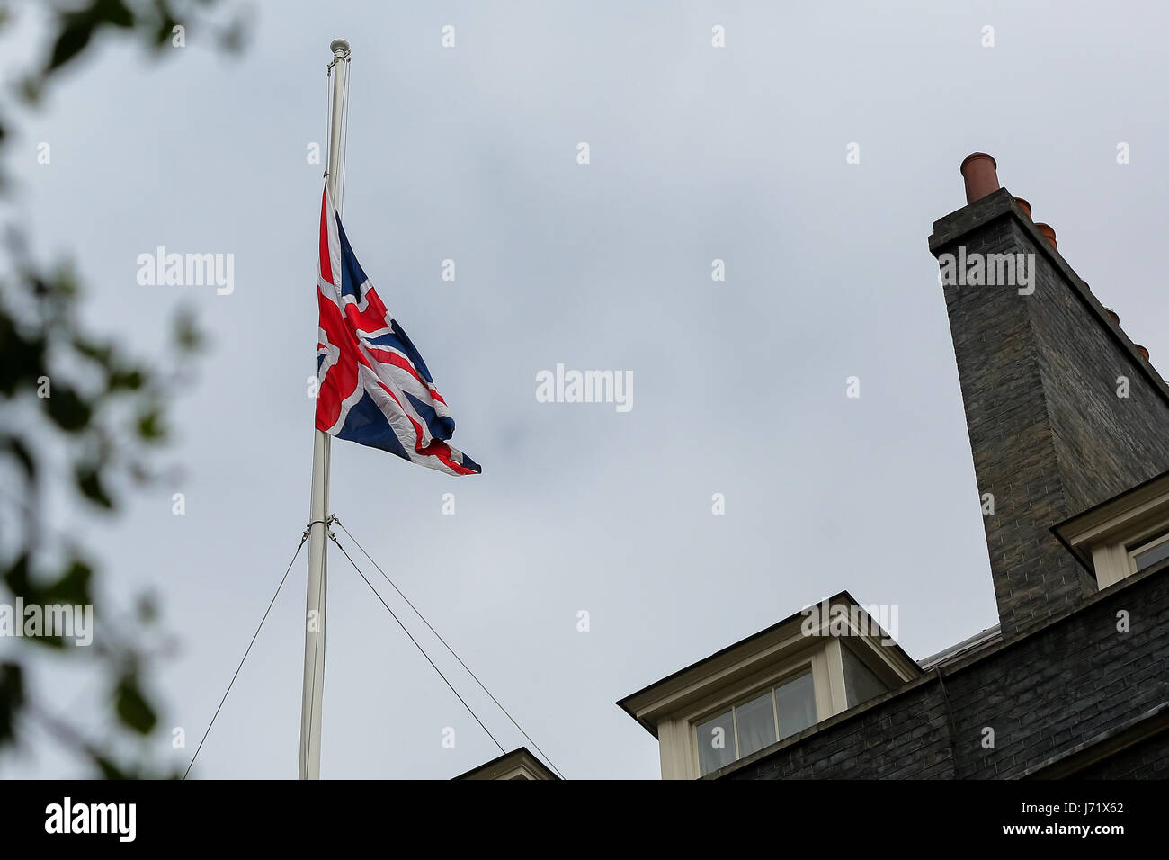 A Downing Street, Londra, Regno Unito. 23 Maggio, 2017. Union Jack flag a metà il montante in Downing Street al rispetto a quelli uccisi e feriti in ultima notte di terrore attentato in Manchester Arena. 22 persone sono state uccise e 59 ferite quando un attentatore suicida detonato un chiodo bomba a un concerto pop essendo trattenuto in sede. Credito: Dinendra Haria/Alamy Live News Foto Stock