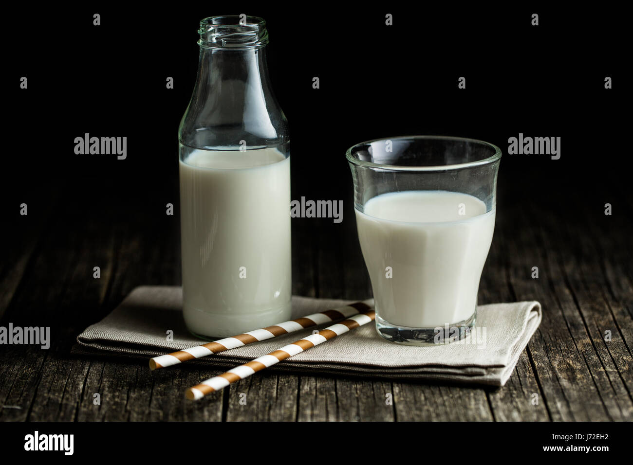 Un bicchiere di latte con bottiglia di latte. Foto Stock