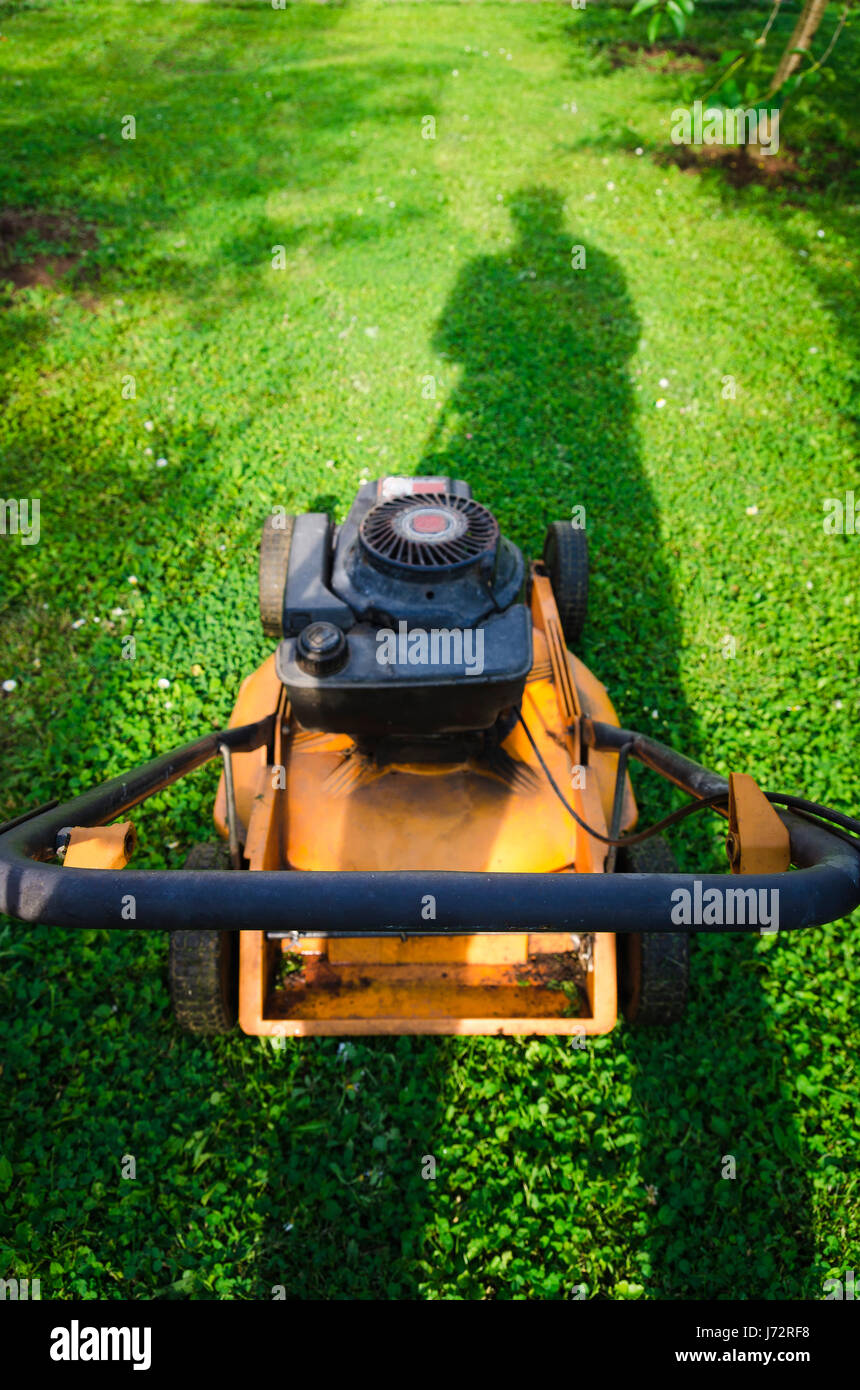 Spingendo il vecchio stile erba benzina verticale del tosaerba Foto Stock