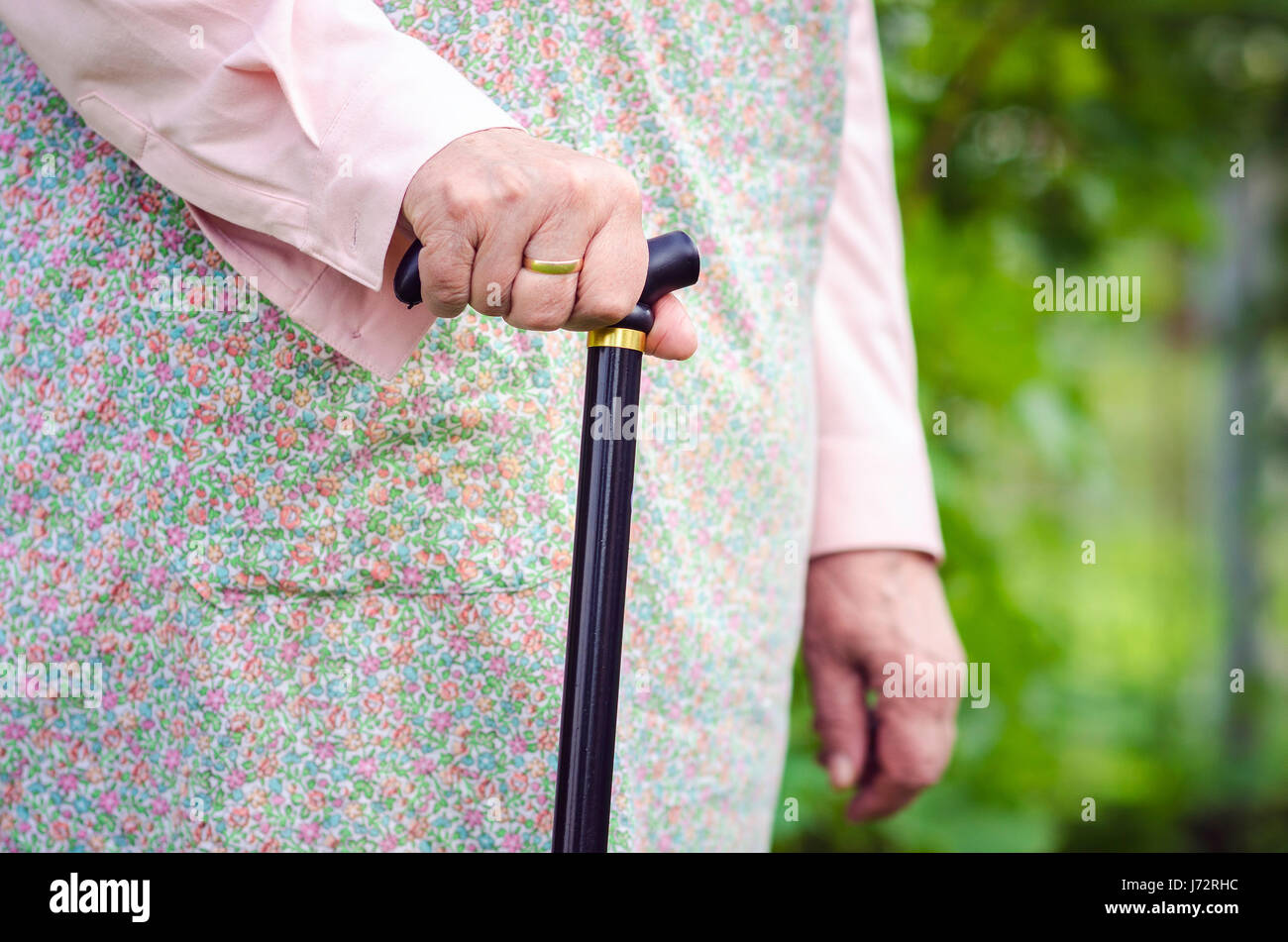 Il vecchio donna obesa camminare con il bastone in orizzontale Foto Stock