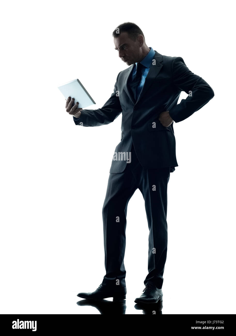Un caucasian business man standing con tavoletta digitale arrabbiato silhouette isolati su sfondo bianco Foto Stock
