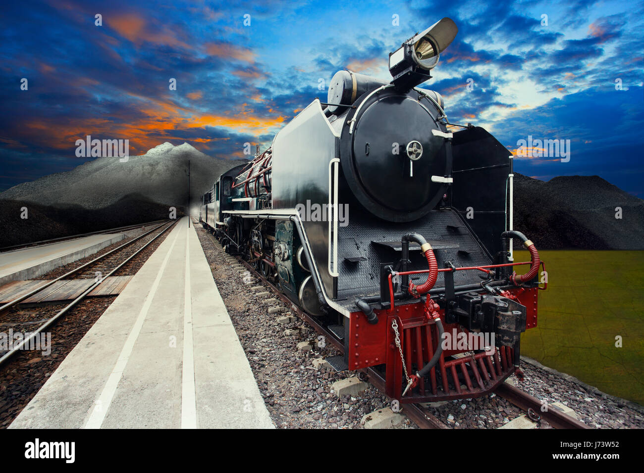 Flusso locomotiva a motore sul treno ferrovie via con belle dusky sky e la scena della montagna Foto Stock