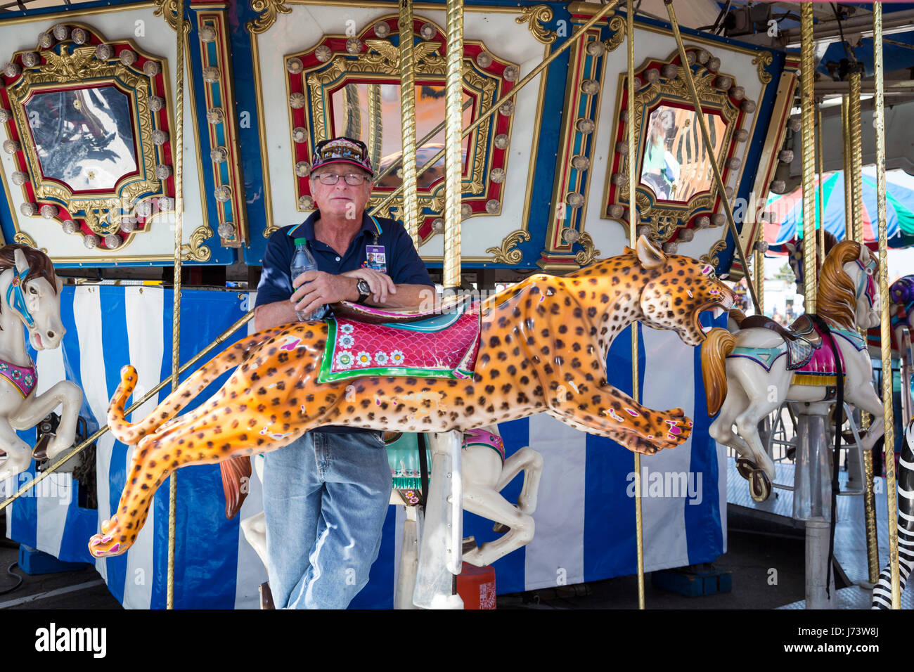 Phoenix, Arizona - un lavoratore di carnevale sulla merry-go-round a Maricopa County Fair. Foto Stock