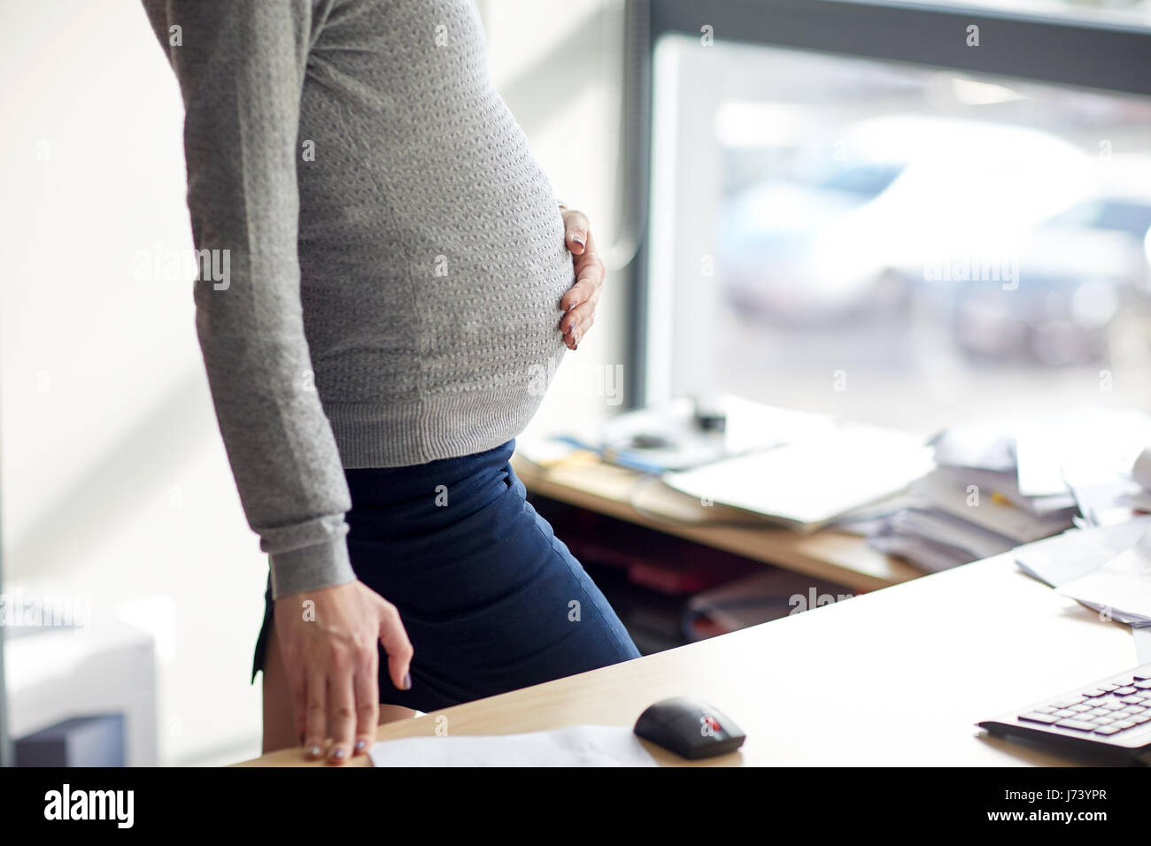 Imprenditrice incinta con il computer in ufficio Foto Stock