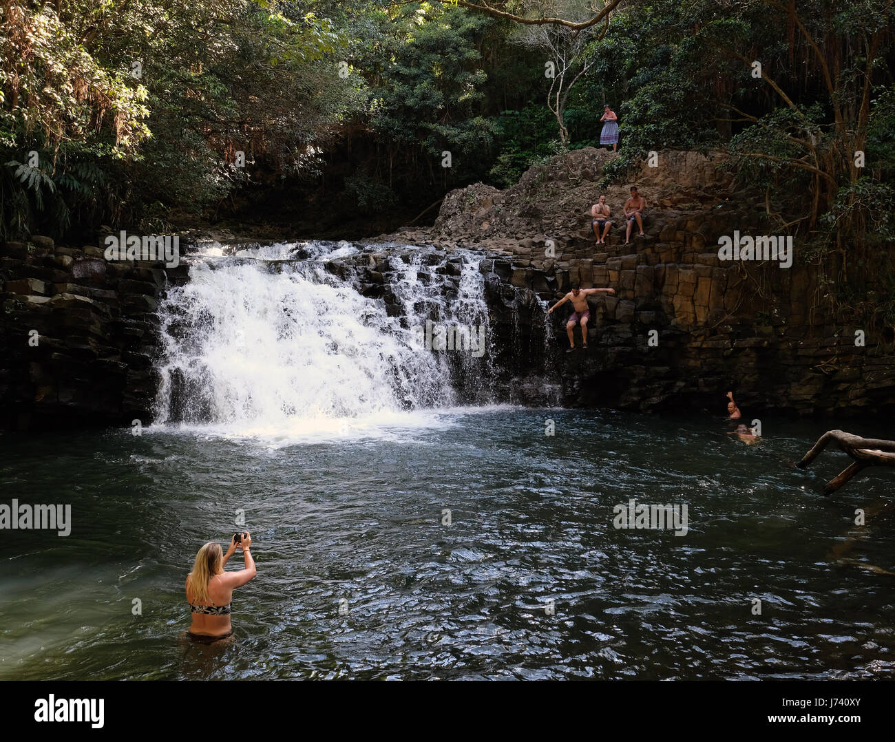 I turisti salto in una profonda piscina a Twin Falls cascata sulla strada di Maui, Hawaii. Foto Stock