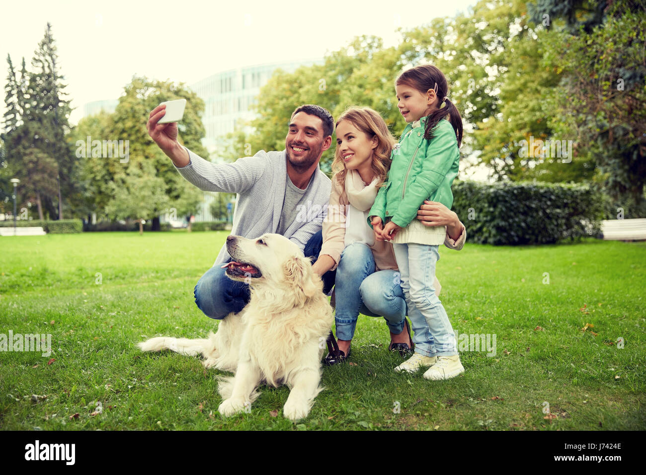 La famiglia felice con il cane tenendo selfie tramite smartphone Foto Stock