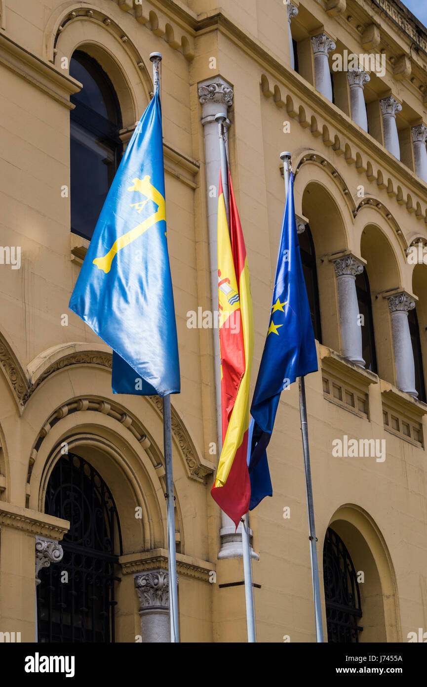 Le bandiere del Principato delle Asturie, il Regno di Spagna e Unione europea al di fuori di un edificio governativo, Oviedo, Asturias, Spagna Foto Stock