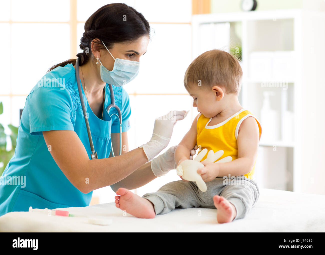 Medico detiene una vaccinazione di iniezione il bambino Foto Stock