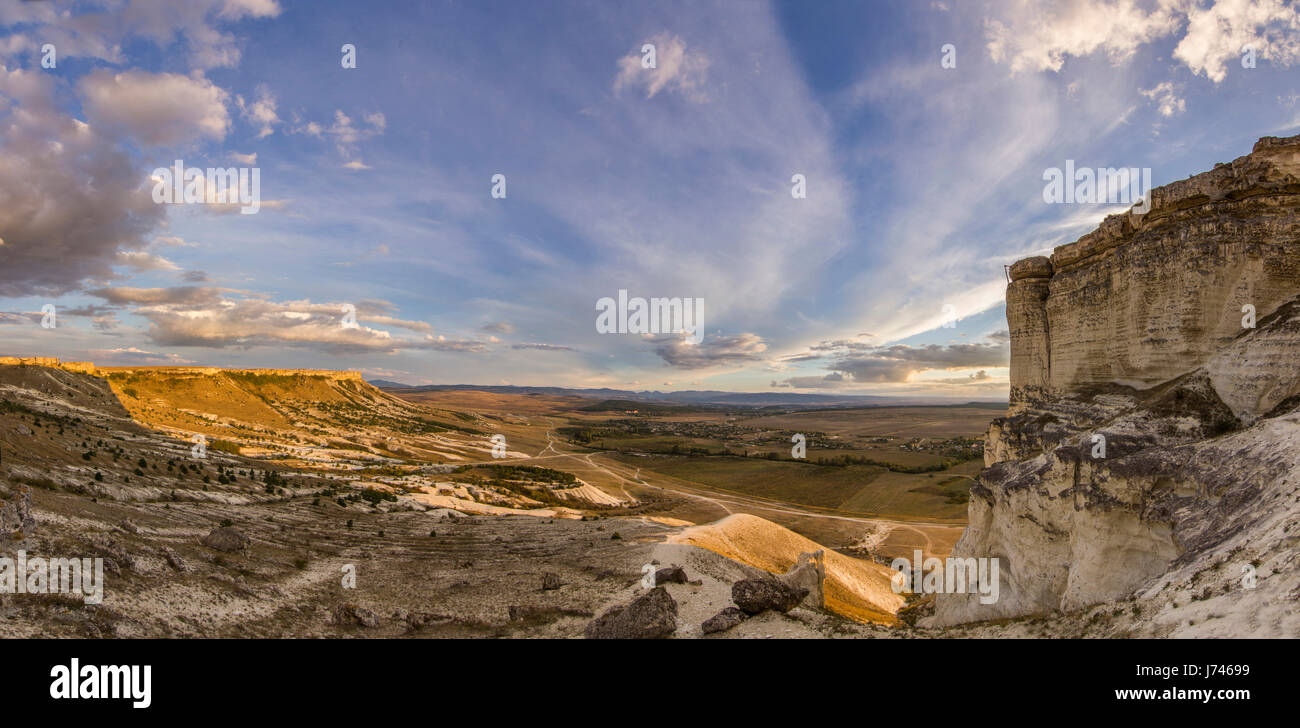 Tramonto vicino White rock con sole e nuvole su sky Foto Stock
