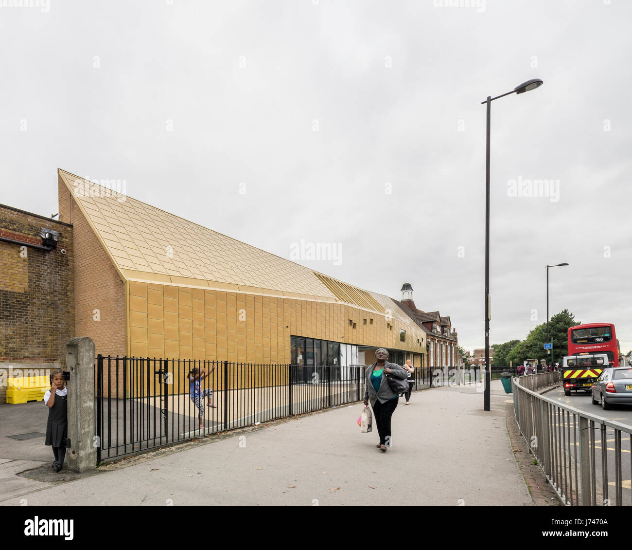 Vista da Whitehorse Road con edificio ingresso e i bambini che arrivano. Whitehorse Manor Junior School a Pegasus Academy, Thornton Heath, Regno Unito. Foto Stock