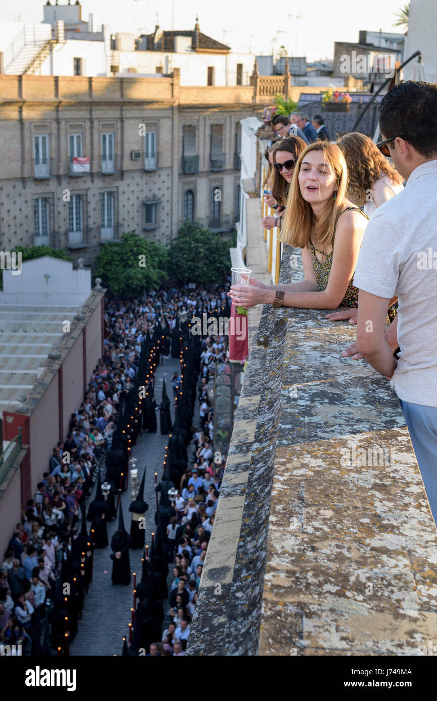 Guardare la gente una processione dalla parte superiore di un edificio mentre godendo il bel tempo e un paio di drink. Foto Stock